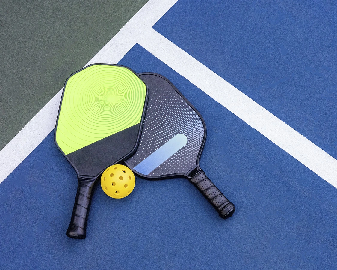 Pickleball paddles and ball on a court